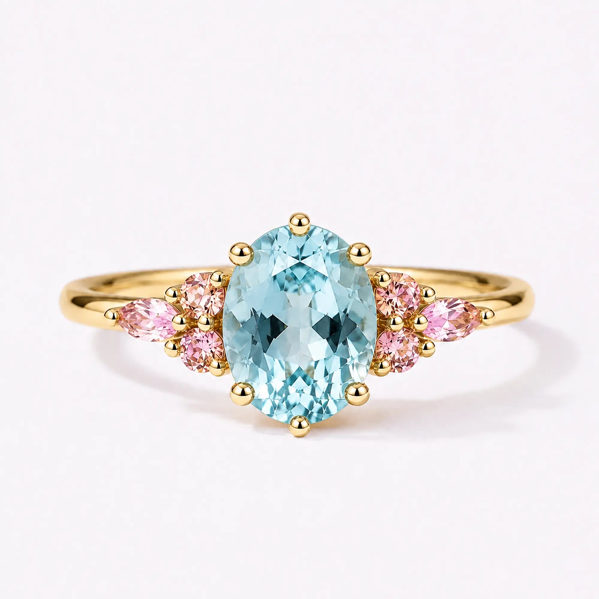 Classic oval aquamarine engagement ring with pink quartz cluster accents in yellow gold