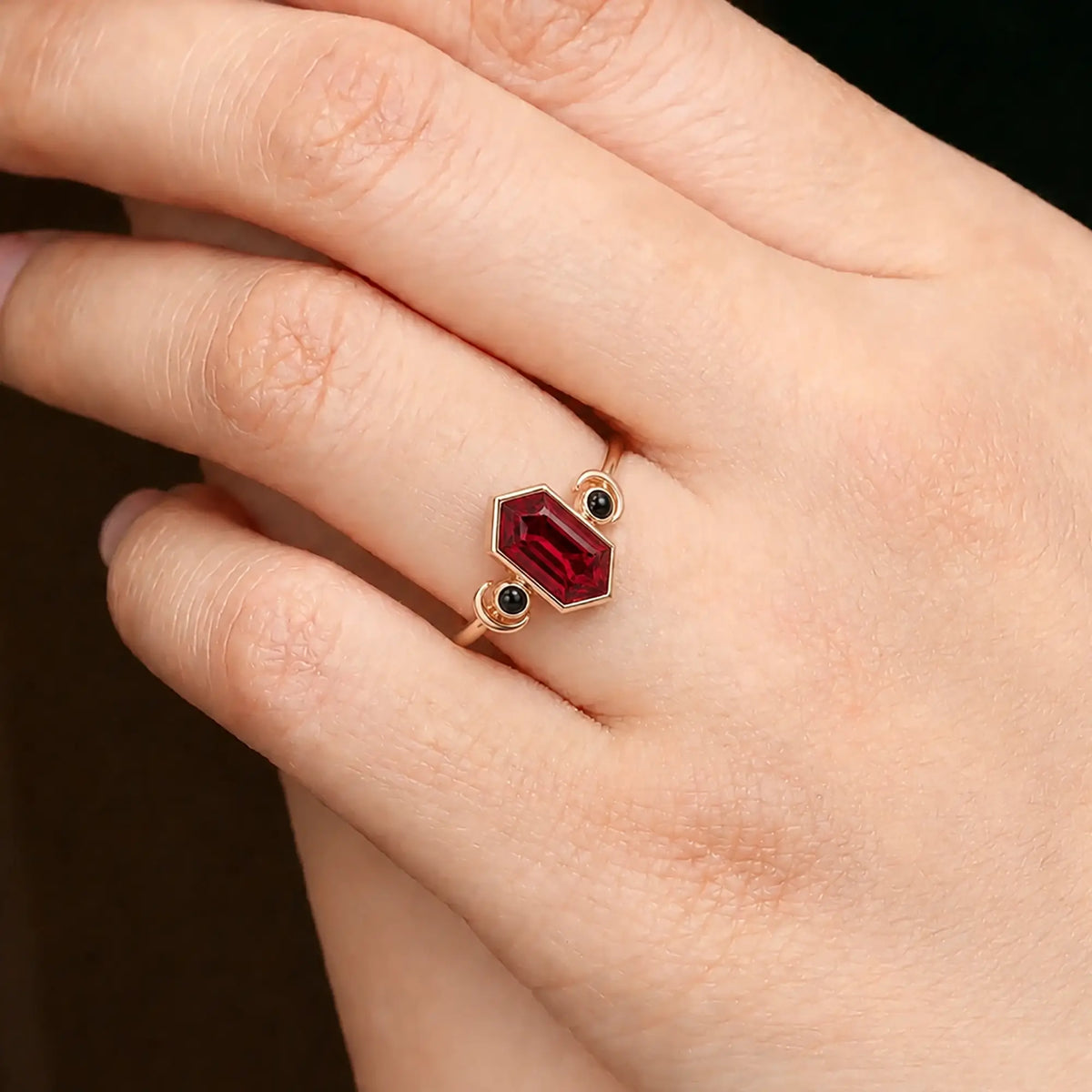 Elongated hexagon ruby ring worn on hand with crescent moon design details