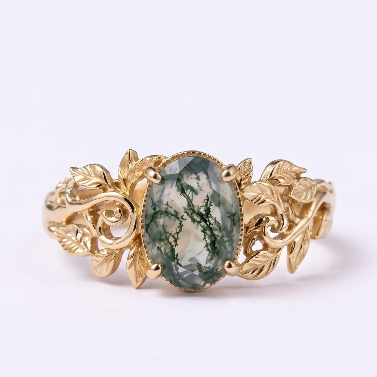 Oval moss agate solitaire engagement ring with sculpted gold leaf details