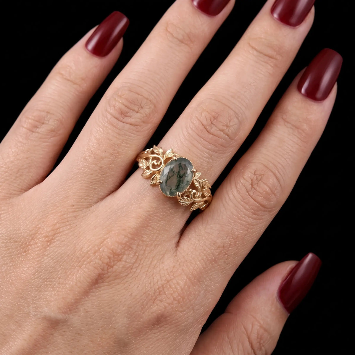 Oval moss agate botanical engagement ring worn on hand
