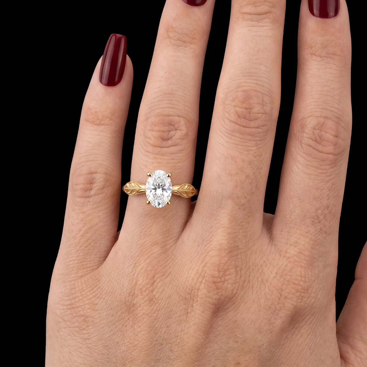Oval lab-grown diamond leaf engagement ring worn on hand