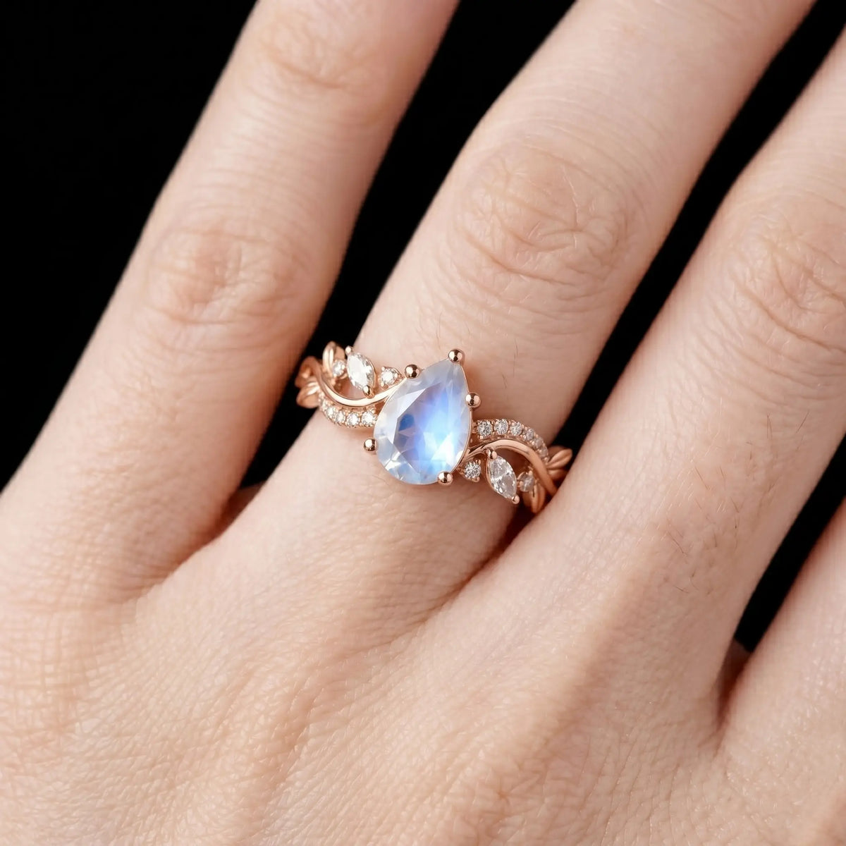 Luminous handmade June birthstone moonstone ring on hand showing ethereal blue adularescence