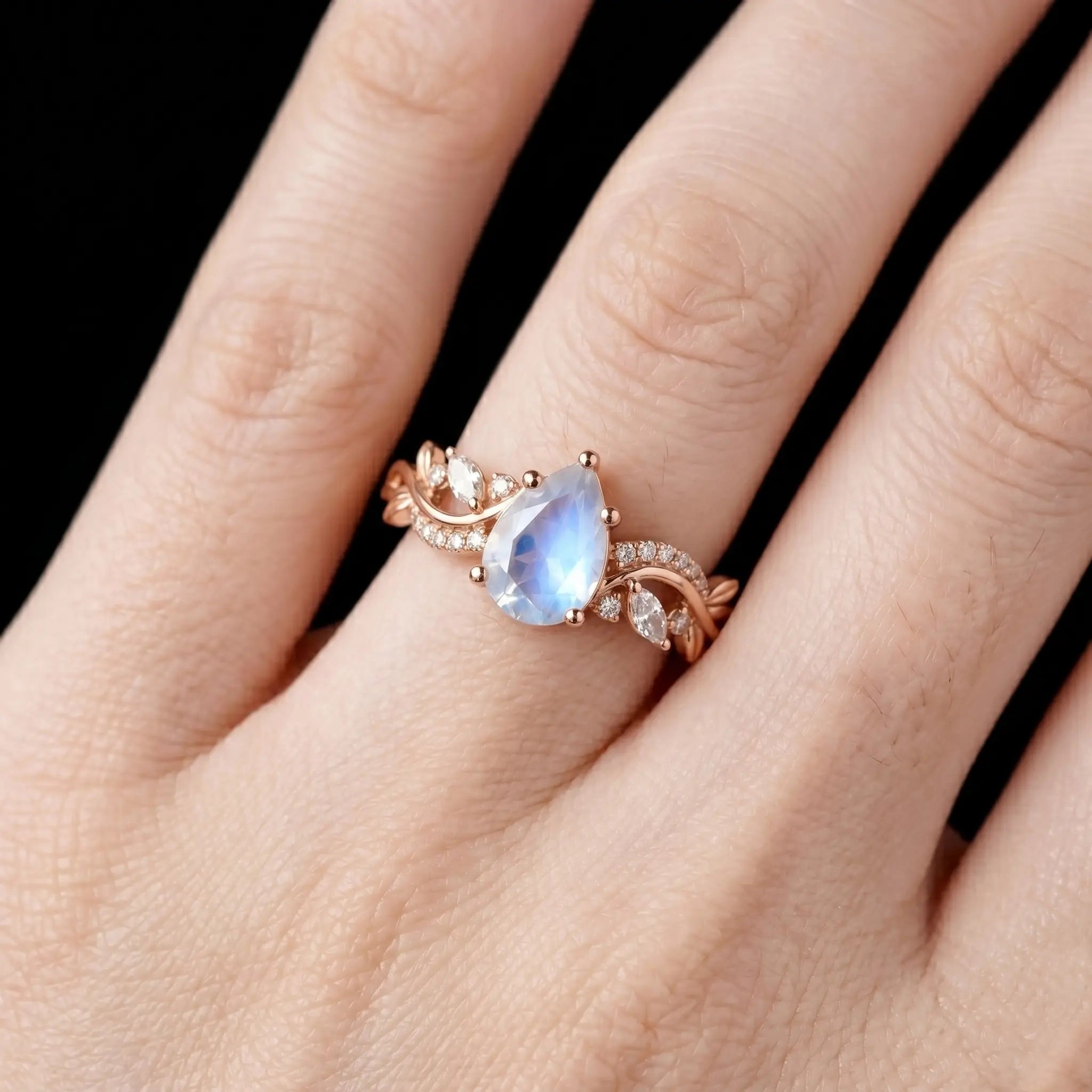 Luminous handmade June birthstone moonstone ring on hand showing ethereal blue adularescence