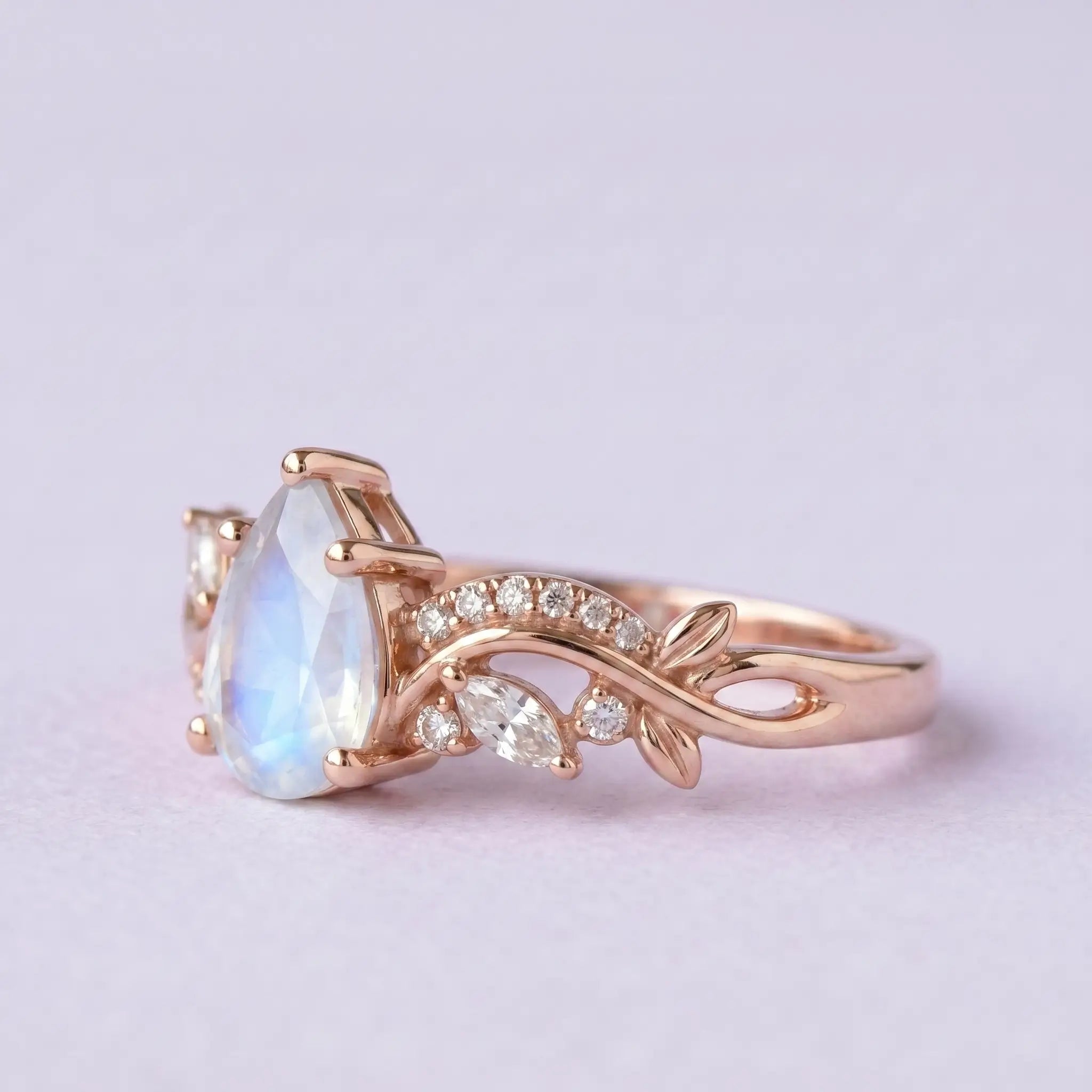 Artisanal gold cluster ring featuring pear natural moonstone and pavé moissanite leaf vines