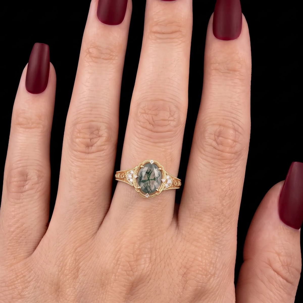 Vintage moss agate engagement ring worn on hand