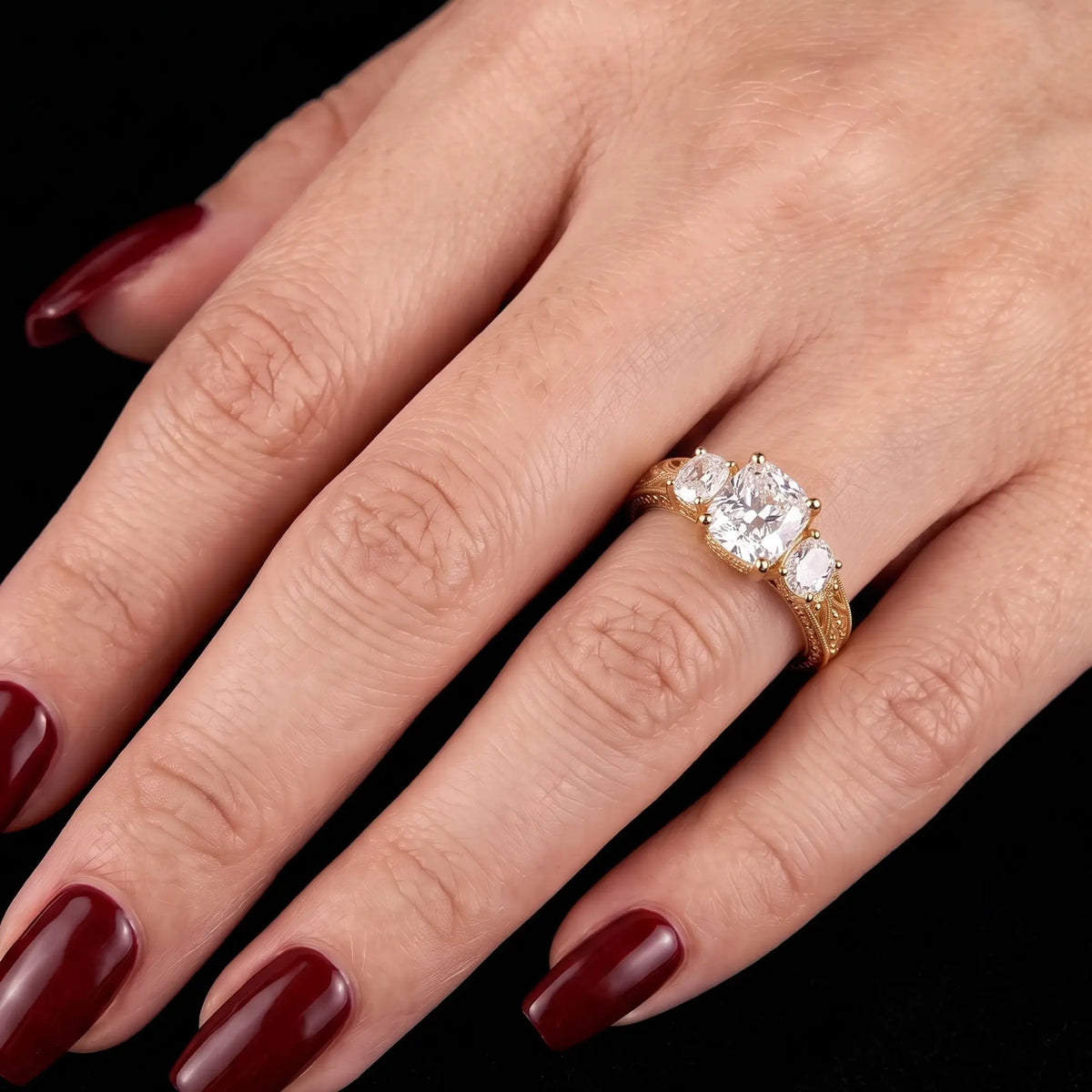 Front view of vintage cushion cut lab grown diamond three stone engagement ring with symmetrical side diamonds