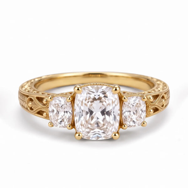 Vintage cushion cut lab diamond three stone engagement ring with ornate filigree and milgrain detailing in yellow gold
