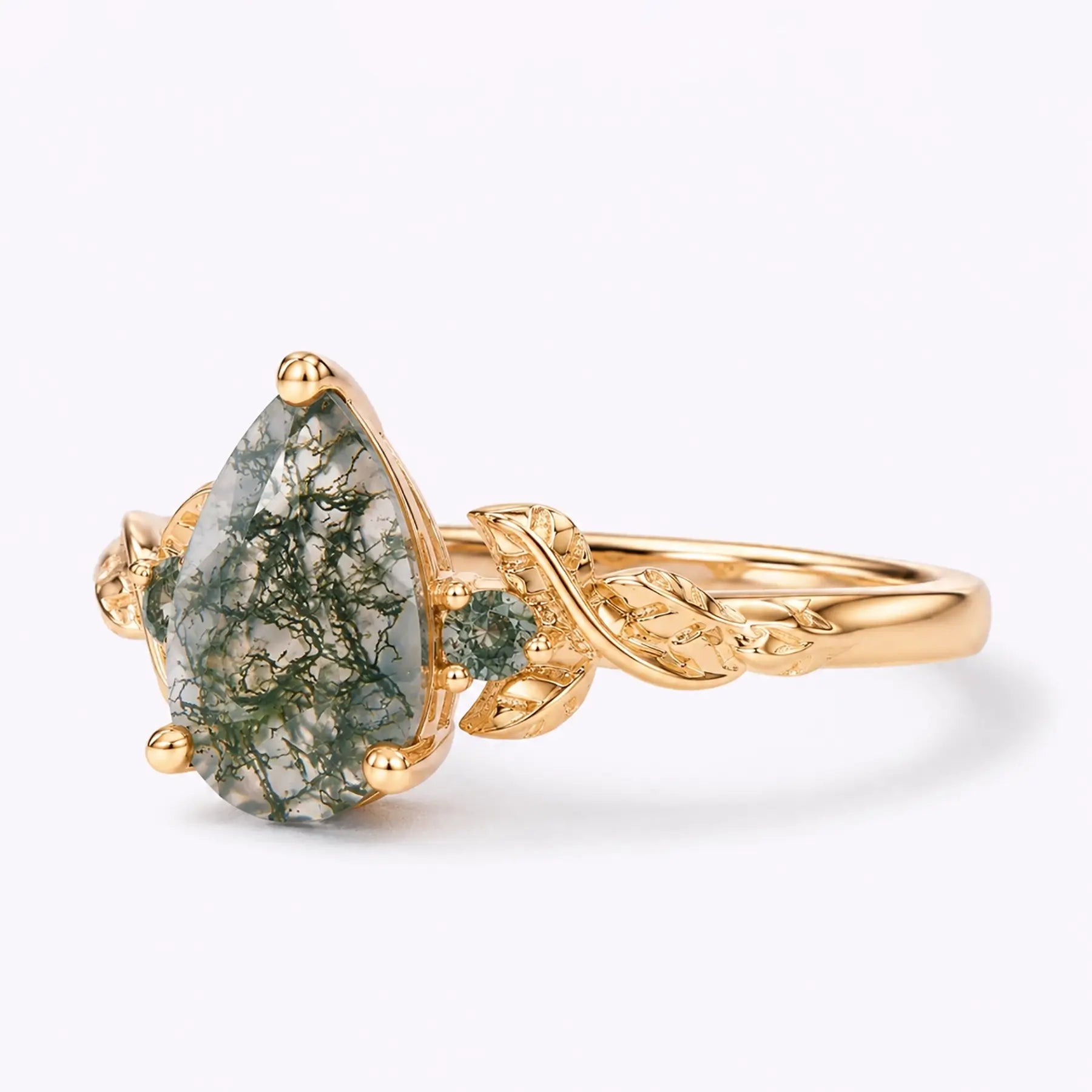 Left view of pear moss agate ring with leaf details and round side stones