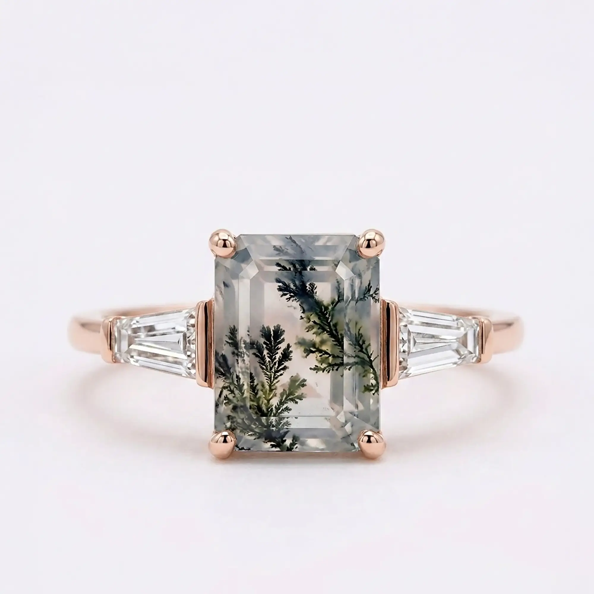 Handcrafted emerald-cut natural moss agate three-stone engagement ring with tapered baguette moissanite accents in solid rose gold by Orleone
