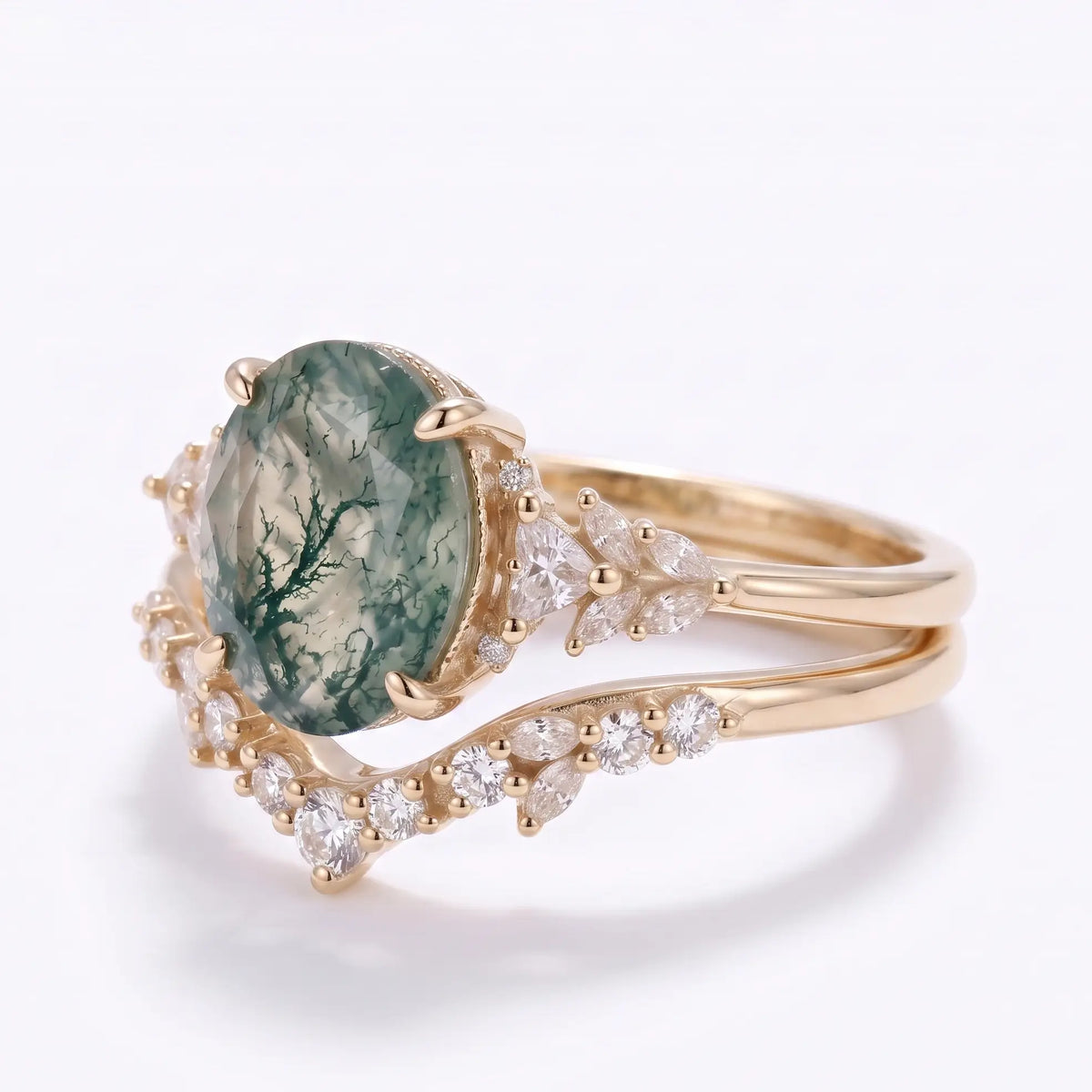Curved wedding band paired with oval moss agate cluster engagement ring