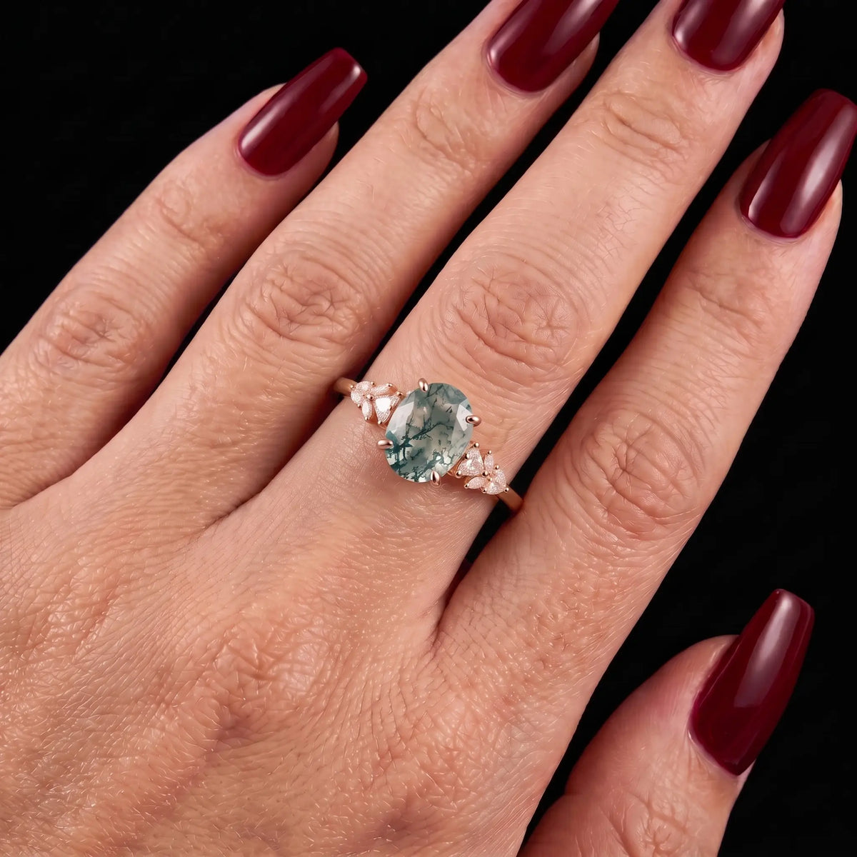 Oval moss agate cluster engagement ring worn on hand