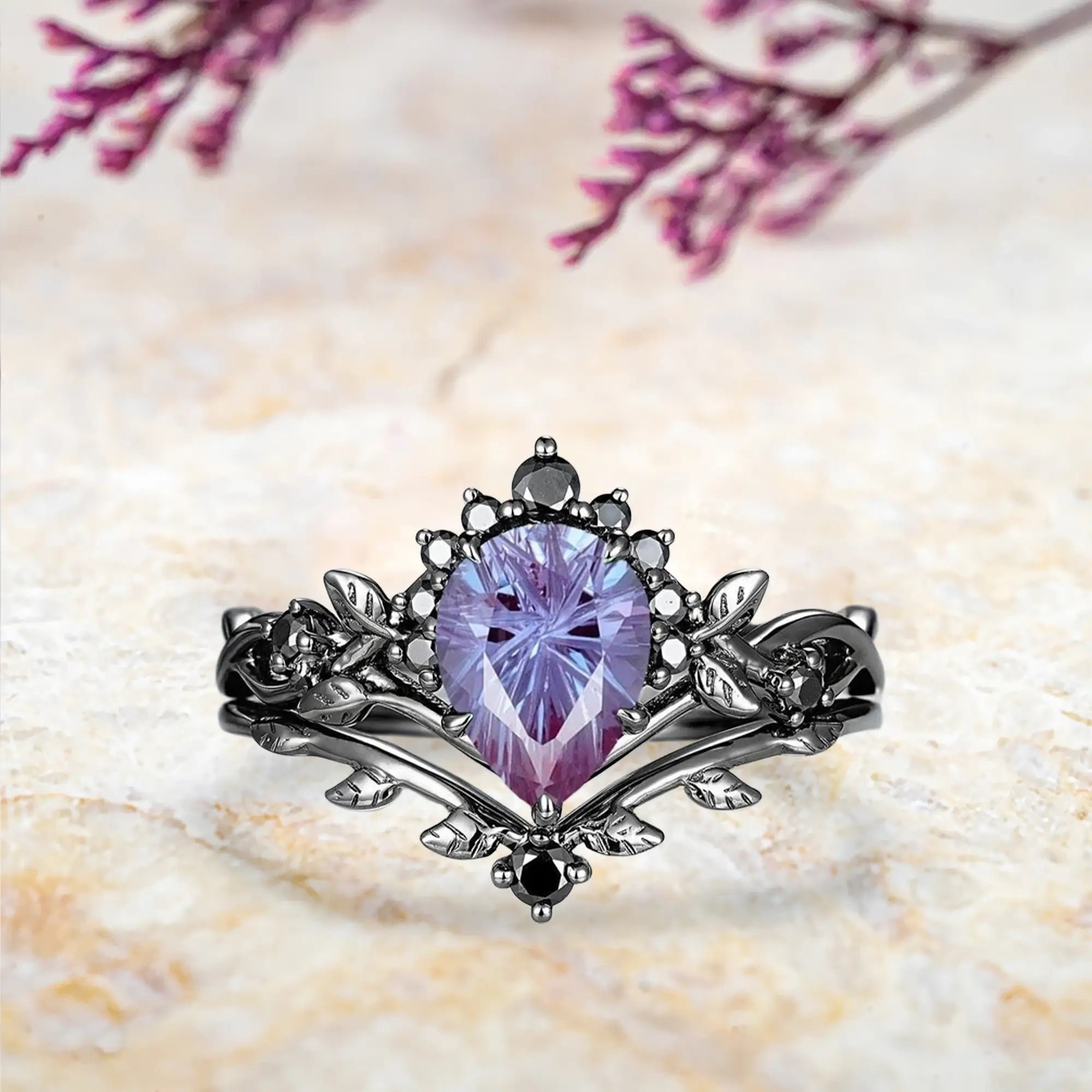 Pear alexandrite fireworks engagement ring with Gothic half halo crown and curved leaf wedding band set in black gold