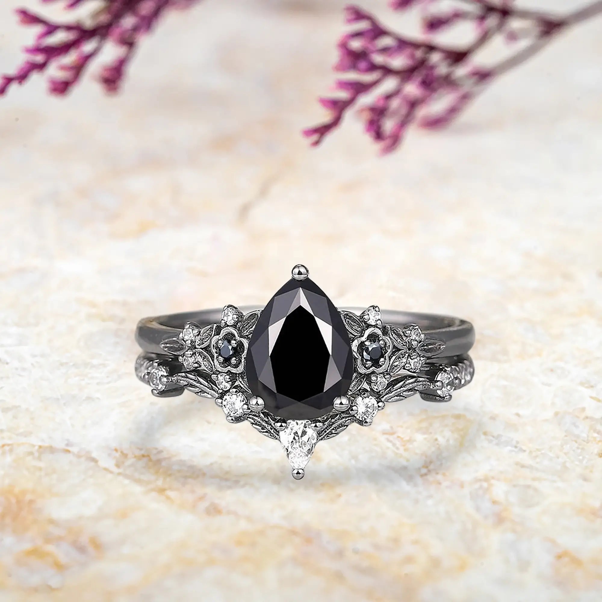 Pear black onyx engagement ring with nature inspired floral cluster and curved leaf wedding band set in black gold
