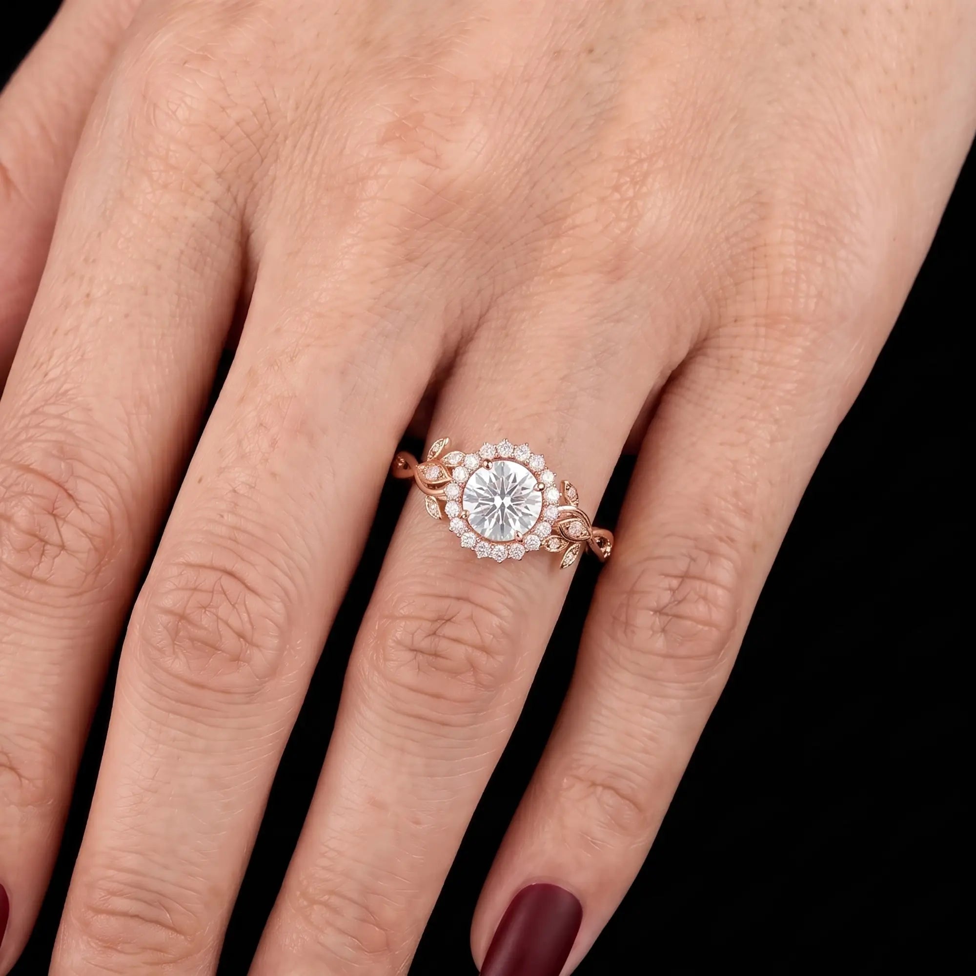 Botanical halo moissanite leaf engagement ring worn on hand in rose gold