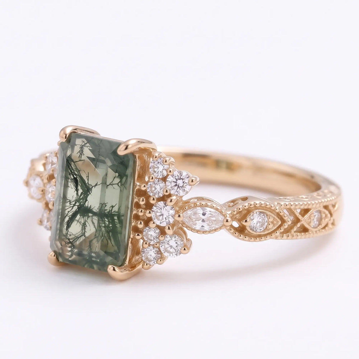 Left angled view of Verdelisse emerald cut moss agate engagement ring showing the vintage cluster setting and elegant gold band details.