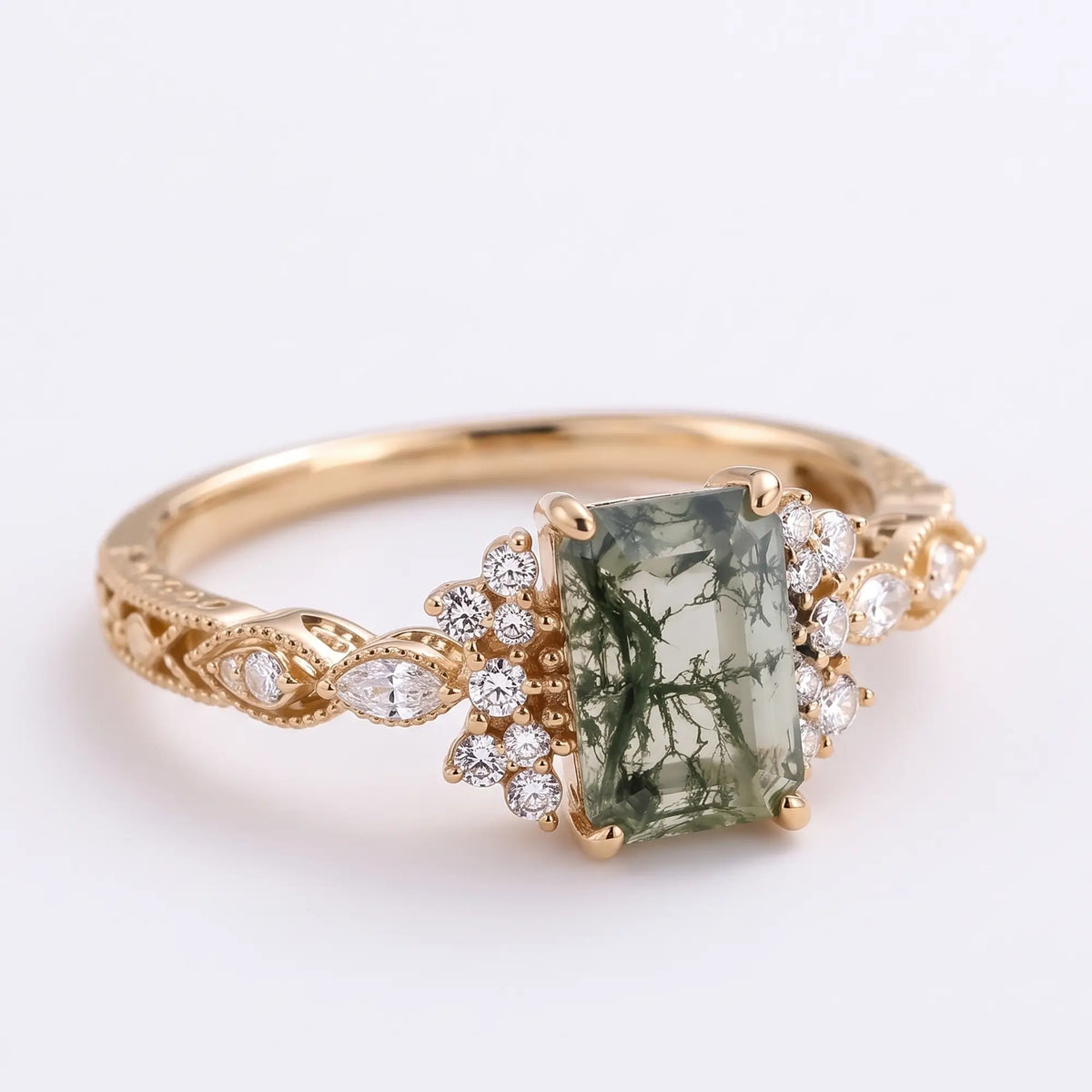 Right angled side view of Verdelisse moss agate cluster engagement ring highlighting the emerald cut center stone and refined vintage styling.