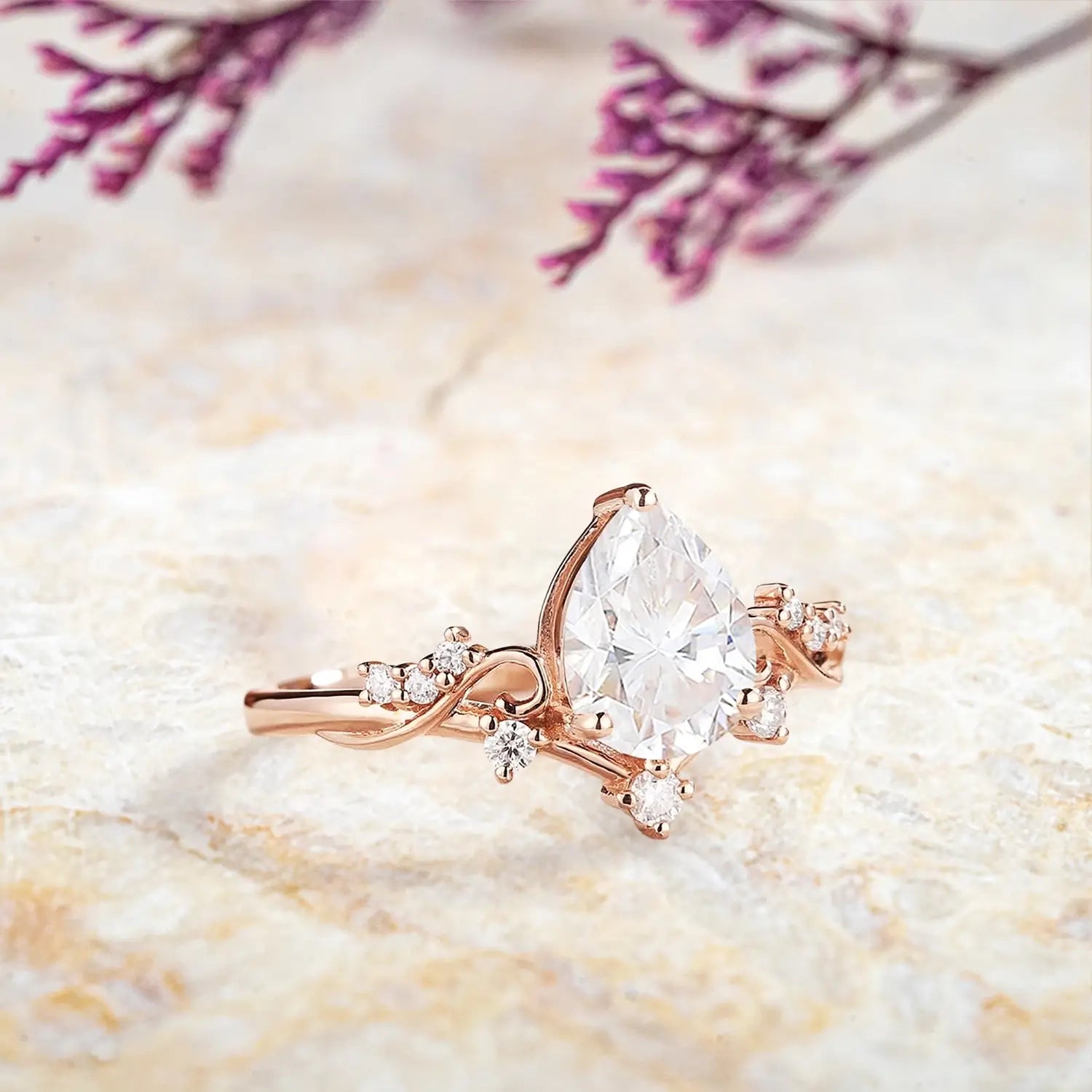 Close up detail of pear moissanite center stone with vintage diamond cluster and symmetrical setting